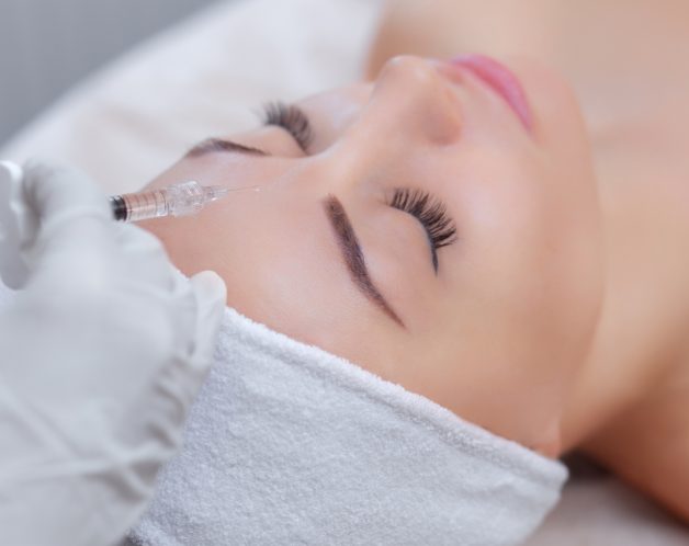 The doctor cosmetologist makes the Rejuvenating facial injections procedure The doctor cosmetologist makes the Rejuvenating facial injections procedure for tightening and smoothing wrinkles on the face skin of a beautiful, young woman in a beauty salon.Cosmetology skin care.