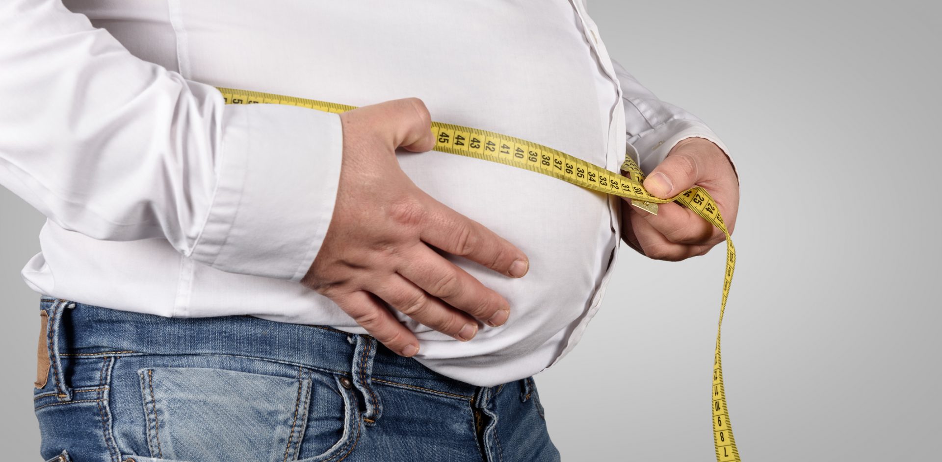 Overweight Man Measuring His Belly with tape measure